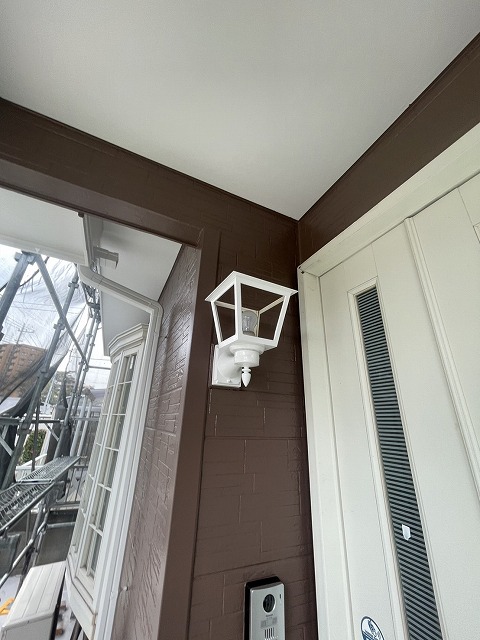 熊谷市村岡で外壁塗装中。終盤の作業で玄関照明、雨樋、雨戸・玄関ポーチ柱塗装。